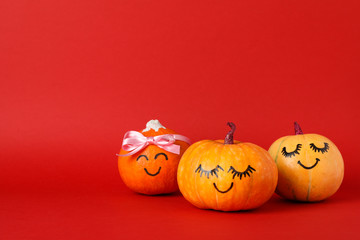 Happy pumpkins on red background, space for text