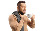 Man suffering a sore thorat and drinking a hot tea