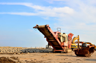 Mobile Stone crusher machine by the construction site or mining quarry for crushing old concrete slabs into gravel and subsequent cement production - obrazy, fototapety, plakaty