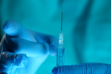 Physician injector arms in sterile uniform holding syringe while operating patient in surgical...
