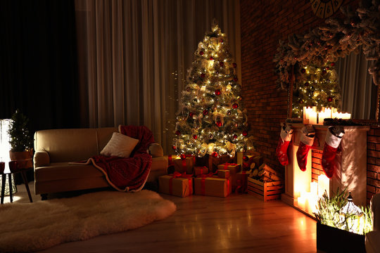 Stylish room interior with beautiful Christmas tree in evening
