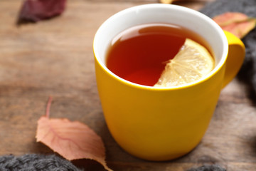 Cup with hot drink on wooden table, space for text. Cozy autumn