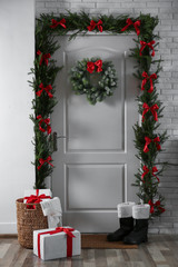 Fototapeta na wymiar Stylish hallway interior with decorated door and Christmas gifts