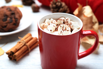 Cup of hot drink and cookies on white wooden table, closeup. Cozy autumn atmosphere