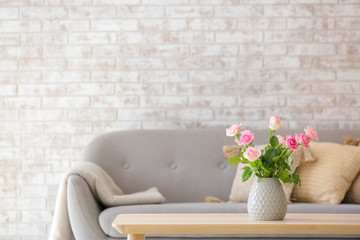 Beautiful rose flowers in vase on table in room