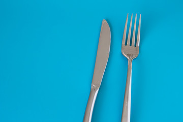 Knife and fork on blue background