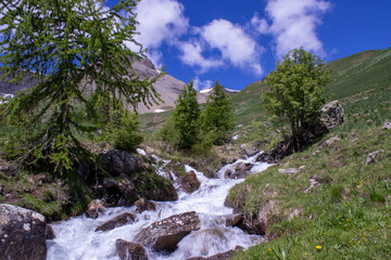 river in the mountains at the col de vars in france