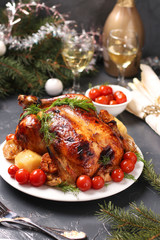 Baked chicken with honey, soy sauce, onion and garlic, served with potatoes and cherry tomatoes, Christmas background, vertical orientation, closeup