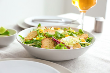 Plate with tasty salad on table