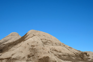 Fototapeta na wymiar Mountain of grit with a blue sky background