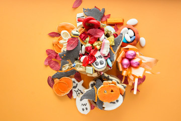 Halloween Jack o Lantern candy bowl with candy and halloween cookies Trick or Treat on orange background