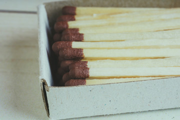 Matches in box, on white background. Macro photography. Close-up shot. Matches in open match-box