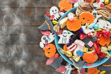 Fototapeta na wymiar Halloween Jack o Lantern candy bowl with candy and halloween cookies Trick or Treat on old wooden background