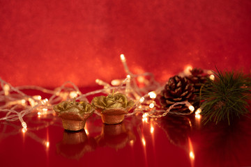 Christmas pineapple and golden candles with lights on bright red background. christmas concept