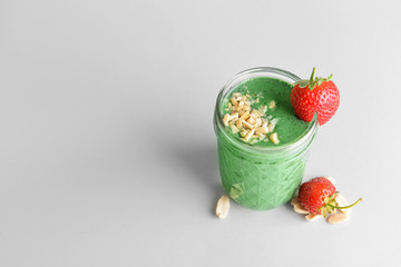 Glass of healthy spirulina smoothie on color background