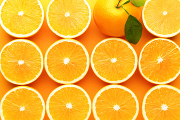 Whole orange among cut ones on color background. Concept of uniqueness