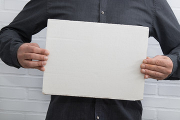 businessman holding blank cardboard sign