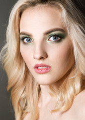 Naklejka premium Sexy beauty face. Glamour portrait of beautiful woman model with evening makeup. Fashion shiny highlighter on skin, sexy lips make-up and perfect eyebrows. Green eye shadow.