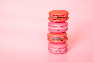 Pink macaroons in a stack on a fashionable coral background