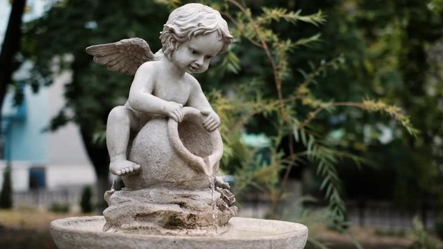 Little angel cupid boy fountain pours water