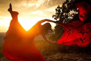 Dancer throwing red fabric into the wind in Connecticut.