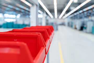 Row of red plastic containers in factory warehouse, Stuttgart, Germany