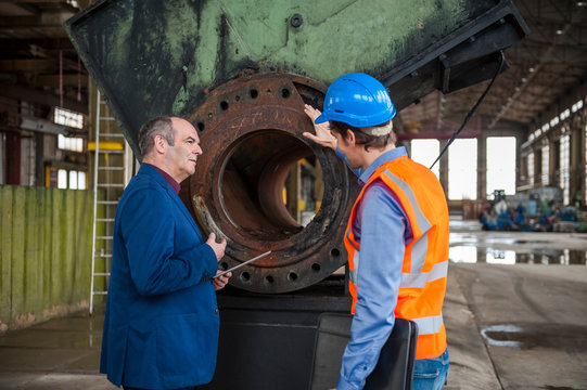 Manager and worker talking in factory hall