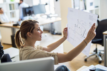 Woman in office looking at plan
