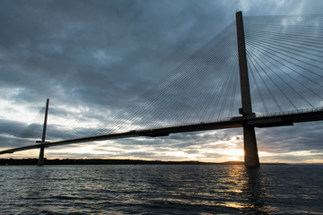 Queensferry Crossing bridge at sunset. The bridge is spanning over Firth of Forth bay. Scotland, UK.