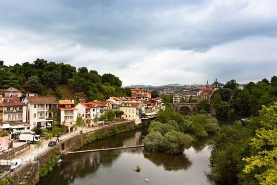 River canal by buildings in town at Duoro Valley against cloudy sky