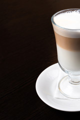 Mug of latte, on a dark, wooden background.