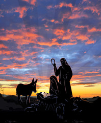 Nativity Christmas scene with black silhouettes highlighted against a colorful sunset with rays shining down on the baby in a manger.
