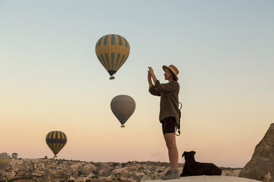 Young woman and hot air balloons, Goreme, Cappadocia, Turkey