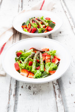 High angle view of fresh salad in bowls and napkin wooden table