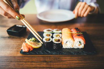 Close-up of a woman eating sushi in a restaurant