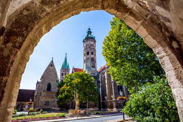 Low angle view of Naumburger Dom and trees against sky seen from archway