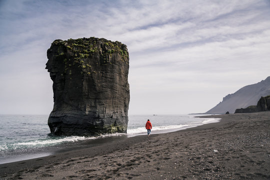 Woman on lava beach in South East Iceland, walk at the sea