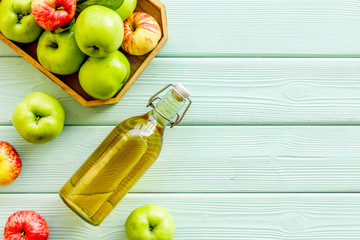 Vinegar made from fresh apple on green wooden background top view copy space