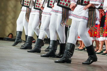 Close up of legs of young Romanian male dancer in traditional folkloric costume. Folklore of Romania