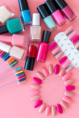 Obraz na płótnie Canvas Сhoose nail polish. Polishes and color samples on pink background top view mockup copy space