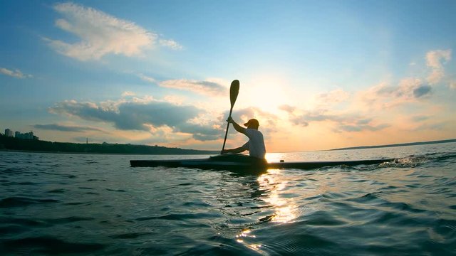 Male paddler is rowing towards the shore