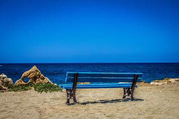 Fototapeta na wymiar ocean beach with blue bench