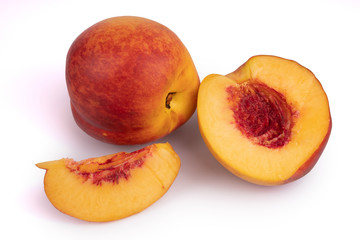 A set of cutted juicy nectarine and a whole one laying on white background