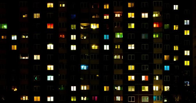 Night panorama time lapse of light in windows of multistory buildings. life in big city