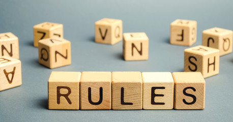 Wooden blocks with the word Rules. Setting rules, laws. Legislation. Religious and folk traditions.