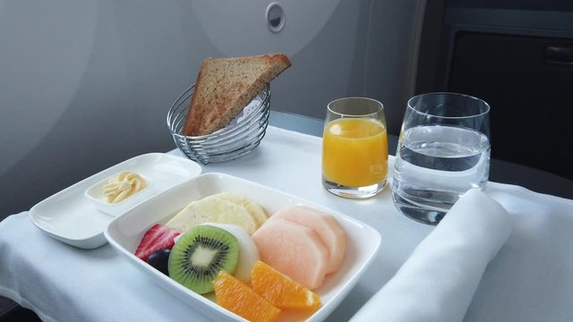 Delicious breakfast with fruit served on board of business class airplane. Tray of food in the airplane. Tray of food on the plane, business class travel. 