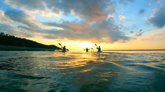 Sunset lake with boaters canoeing in slow motion