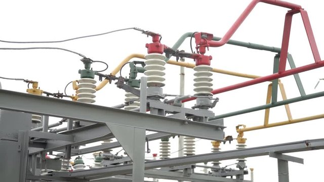 Electrical poles with wires and insulators at the electrical substation. Circuit breaker high voltage. Part of high-voltage substation with switches and disconnectors.