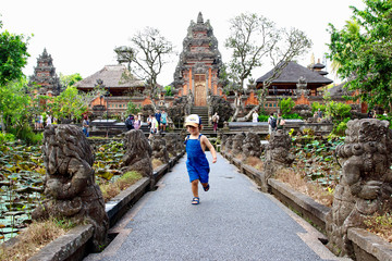 Cute little kid having fun in Pura Taman Saraswati "lotus" temple, a pura  built in 1952 and dedicated to Sarasvati, the Hindu deity of learning and art., Ubud, Bali, Indonesia.