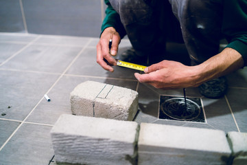 Construction worker craftsman measuring cement brick material in the bathroom of the apartment house work building measurement measure